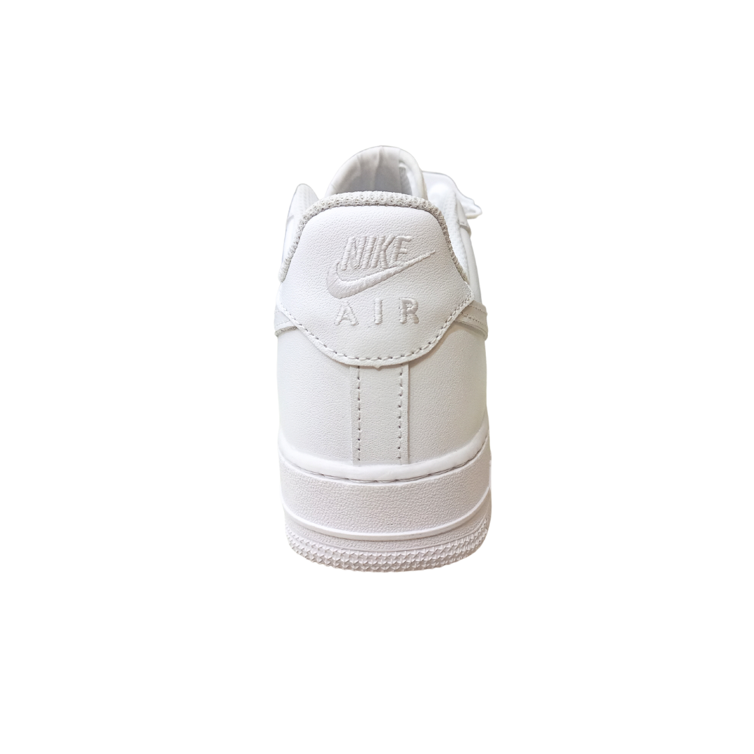 Rear perspective of NAF 1 Low white sneakers with signature heel stitching and brand logo detailing.